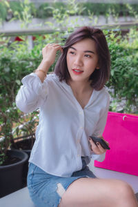 Portrait of a beautiful young woman sitting outdoors