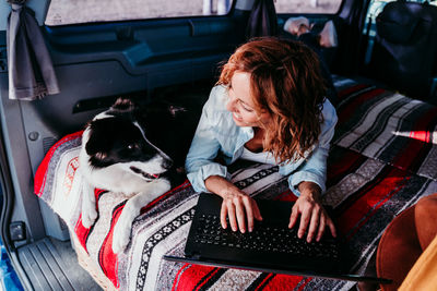 Woman with dog sitting in car