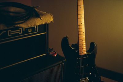 Close-up of playing guitar on wall at home