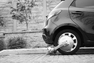 Car clamped on cobbled street