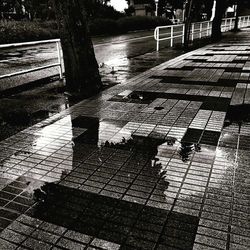 High angle view of park bench by wet street