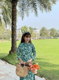 Woman standing by tree on field