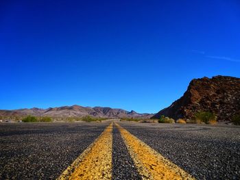 Surface level of road against blue sky