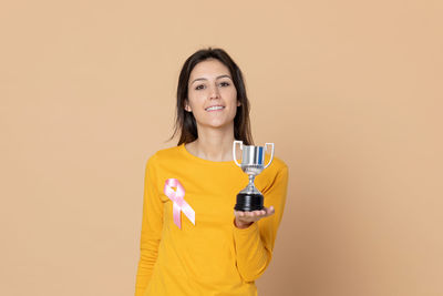 Portrait of a smiling young woman against gray background