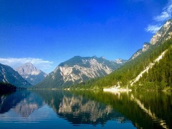 Scenic view of lake and mountains against blue sky