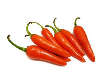 Close-up of red chili peppers against white background