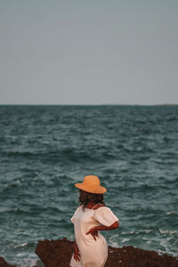 Rear view of woman looking at sea against clear sky