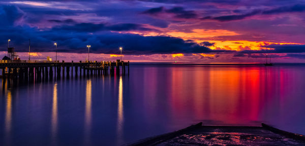 Reflection of clouds in sea at sunset