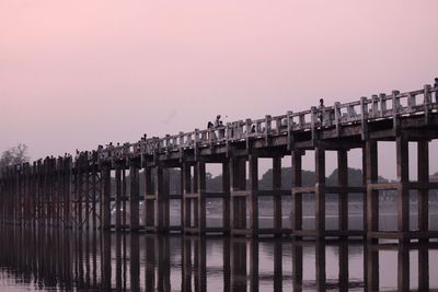 U bein bridge over lake against clear sky during sunset