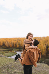 Happy people in love are travel hike in nature in the autumn forest. romantic trip to countryside