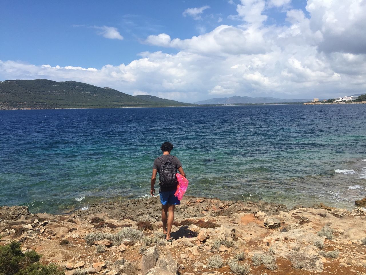 water, sky, full length, rear view, lifestyles, sea, leisure activity, tranquility, beauty in nature, scenics, tranquil scene, standing, casual clothing, nature, cloud - sky, shore, cloud, idyllic