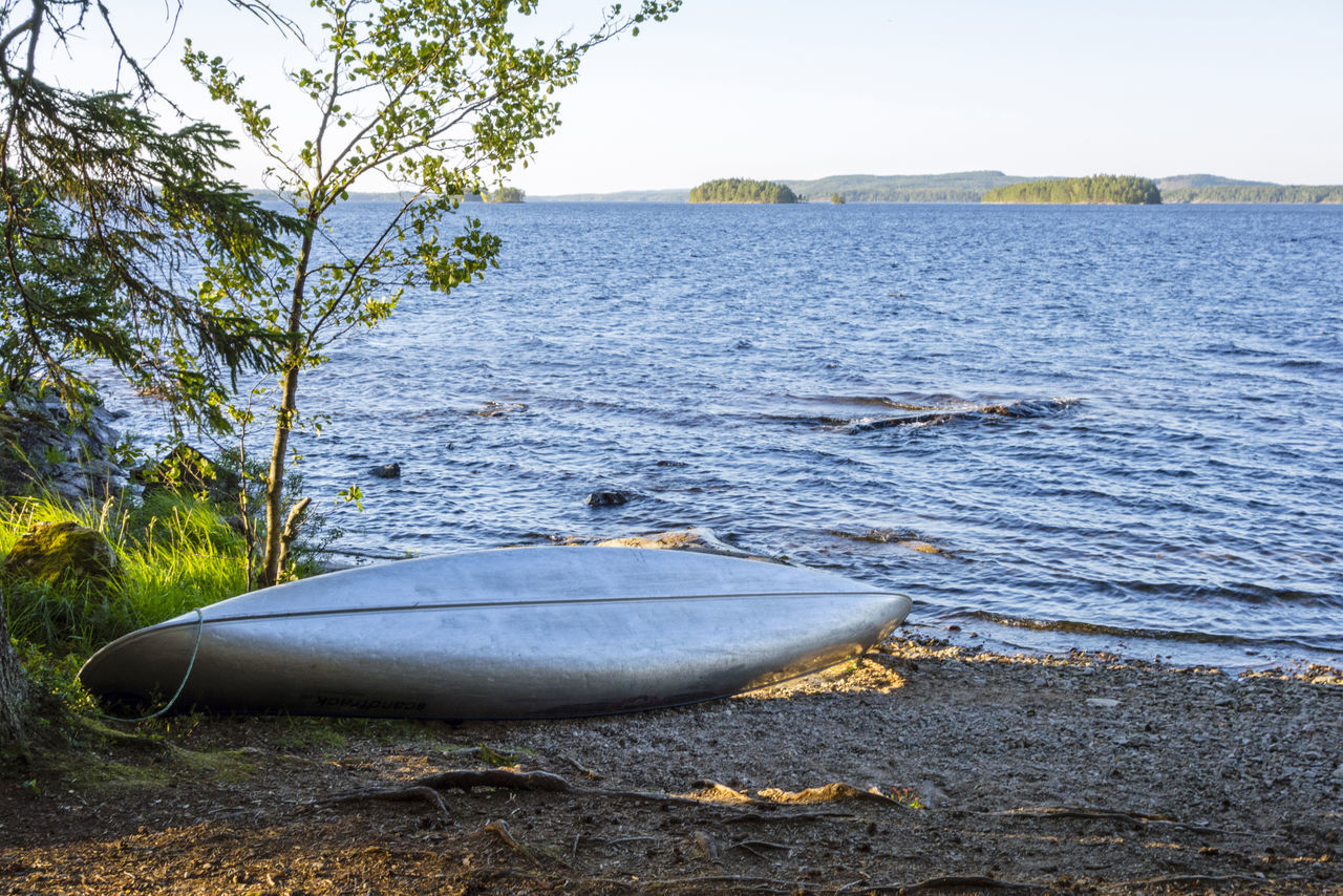 BOAT ON SHORE AGAINST CLEAR SKY