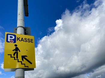 Low angle view of road sign against sky