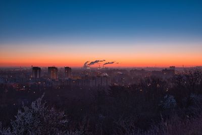 Buildings in city against clear sky during sunset