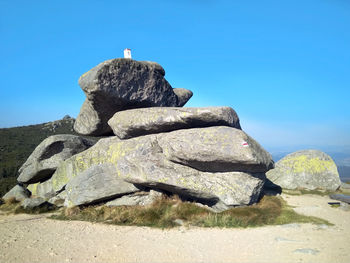 Low angle view of rock formations against clear blue sky