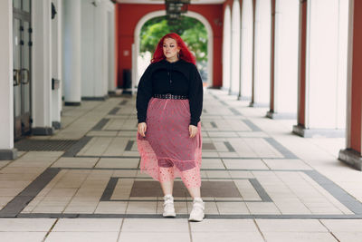 Full length of woman standing on footpath