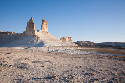 Rock formations in desert against clear blue sky