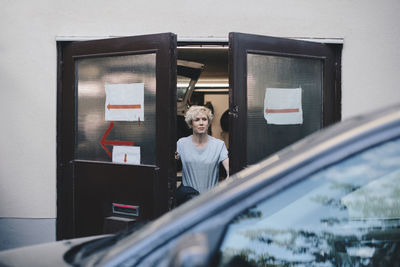 Portrait of woman standing by window