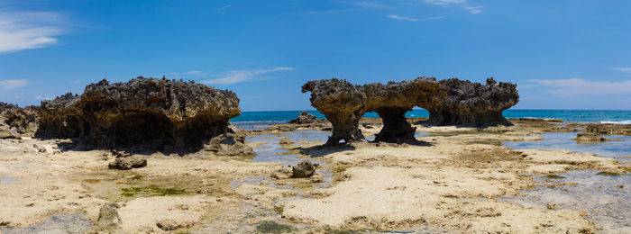 Rocks on beach against sky