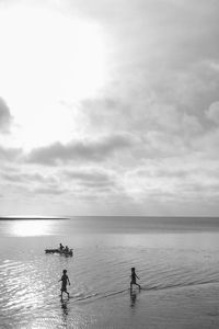 People standing on beach against sky