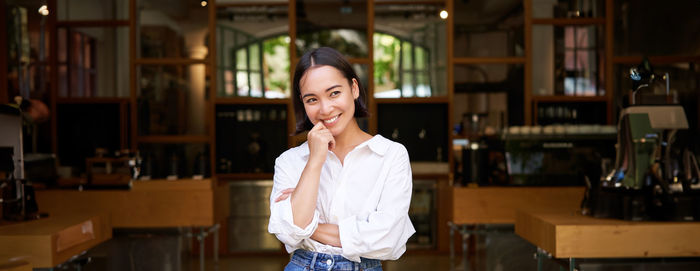 Portrait of young woman standing in library