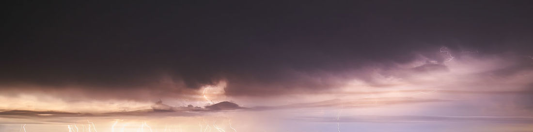 Panoramic view of lightning in sky during sunset