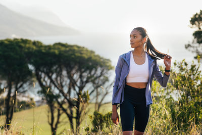 Young woman standing against mountain