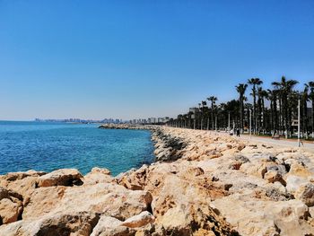 Scenic view of beach against clear blue sky