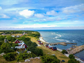 High angle view of town by sea against sky