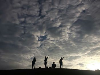 Silhouette men against sky during sunset