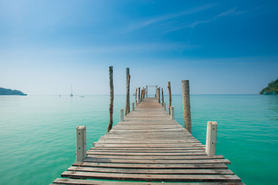 Pier over sea against blue sky