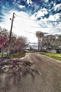 Empty road against cloudy sky