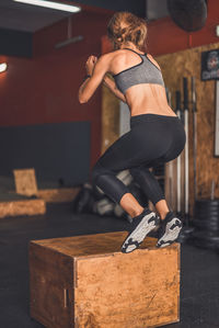 Full length rear view of woman skateboarding