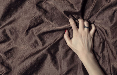 Close-up of woman hand on bed