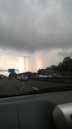 Car on road against cloudy sky