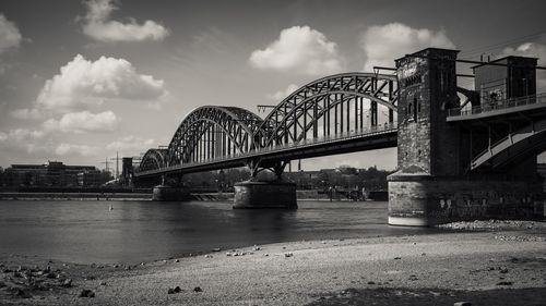 Bridge over river against cloudy sky