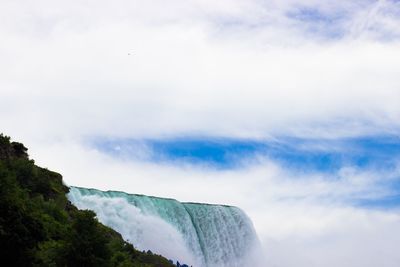 Low angle view of waterfall against sky