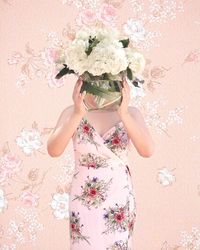 Low angle view of woman holding pink flower