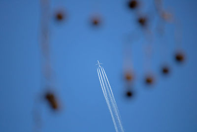 Low angle view of airplane flying against blue sky