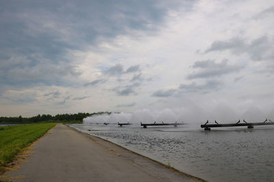 Scenic view of road by sea against sky
