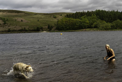 High angel view of woman and dog in lake