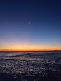 Scenic view of sea against clear sky at sunset