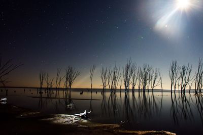 Scenic view of lake against sky at night