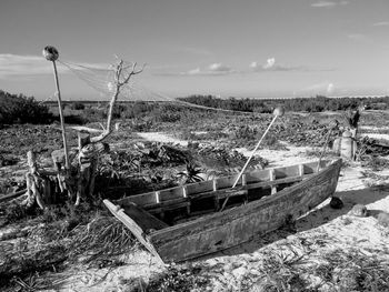 Abandoned boat moored on beach against sky