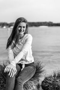 Portrait of smiling young woman sitting outdoors