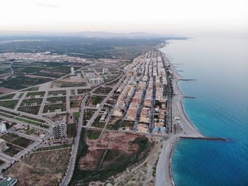 High angle view of buildings by sea against sky