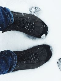 Low section of person standing on snow