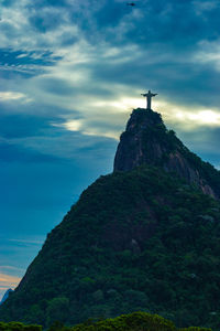 Low angle view of cross on rock against sky