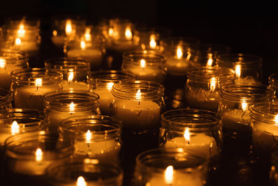 Close-up of illuminated candles in jar
