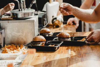 Man holds in his hand burgers at a burger feast. dinner hamburger food feast party. big burger in